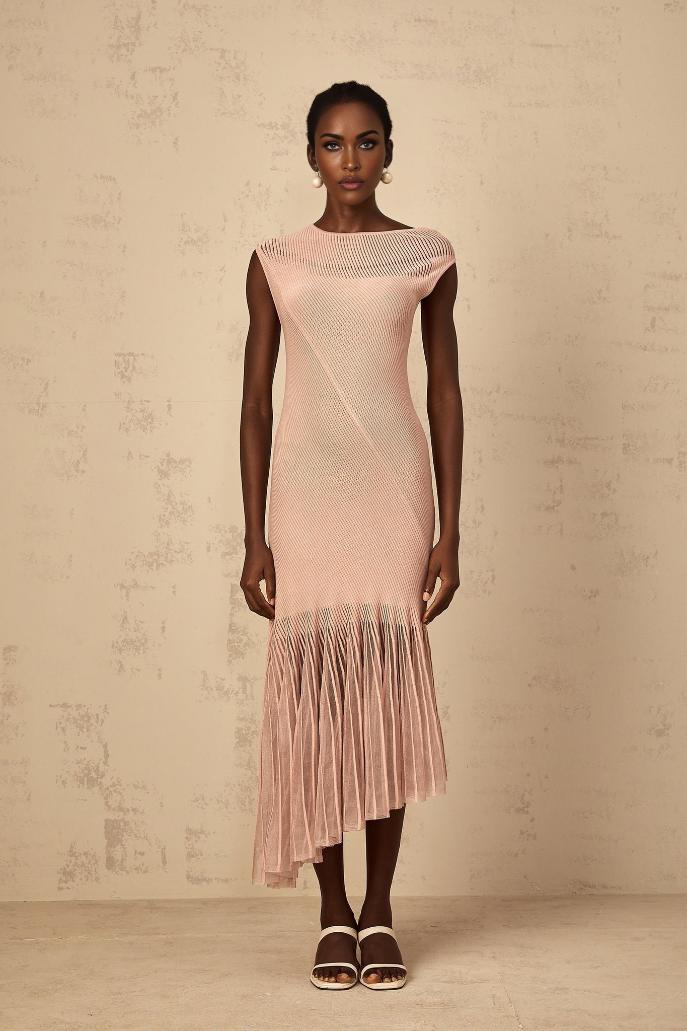 Woman wearing a dusty pink midi dress with ribbed knit fabric and tulle panel details