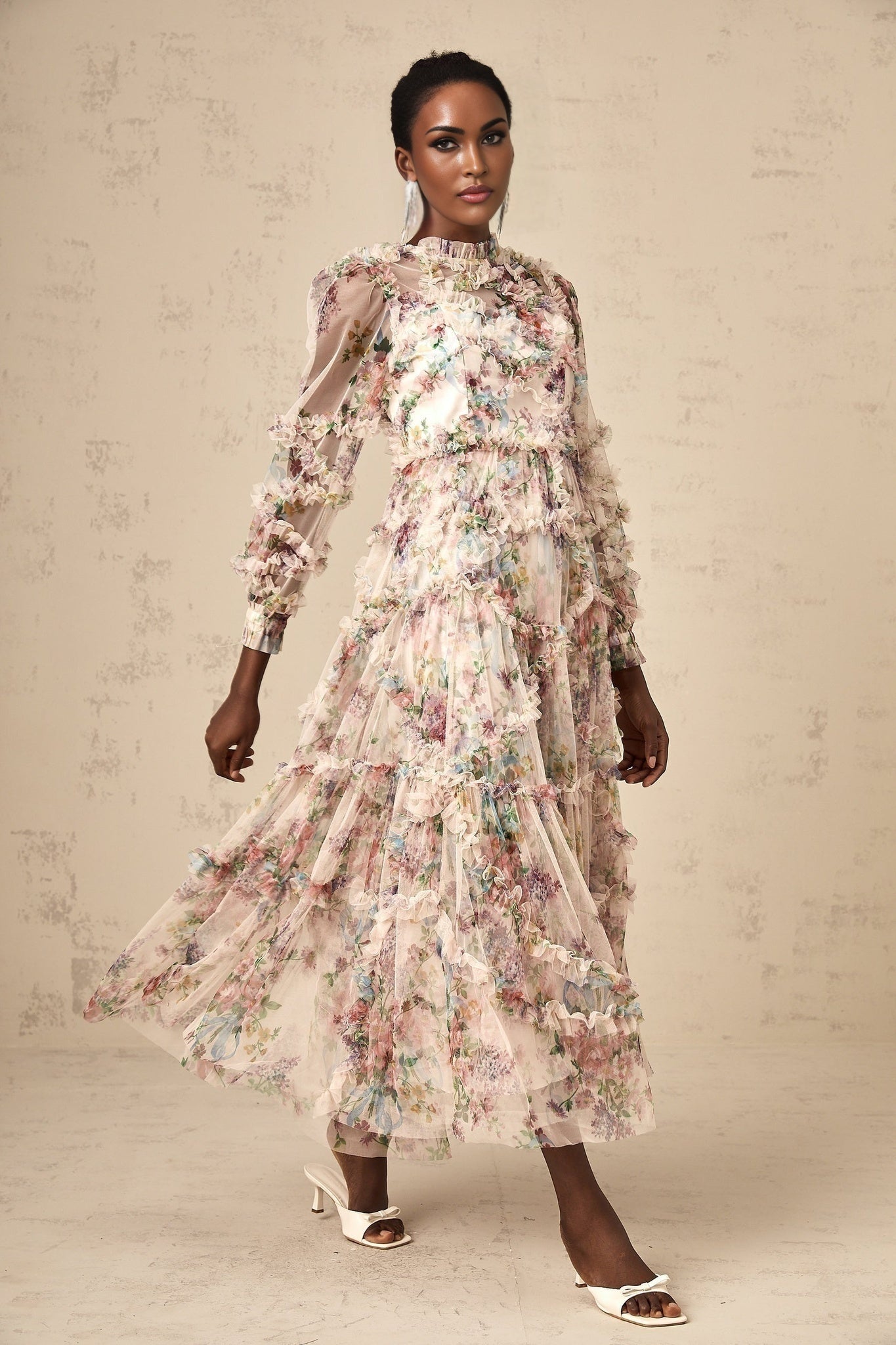 Woman wearing a floral patterned midi dress with ruffled tulle details and a feminine silhouette