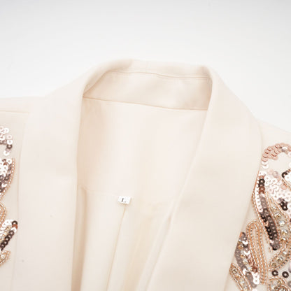 Woman wearing a formal blazer dress with sequin embellishments and sparkly details