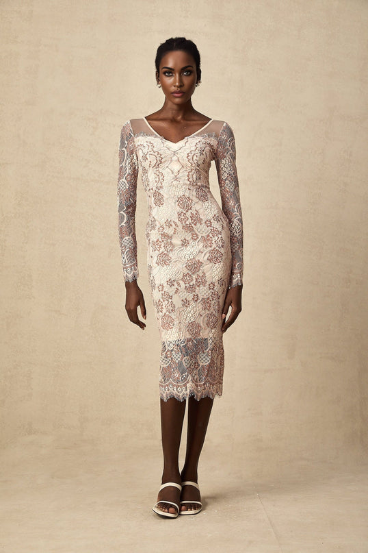 Woman wearing a formfitting white midi dress with intricate guipure lace pattern standing in elegant pose
