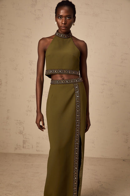 Woman wearing a green daisy patterned top and matching skirt with beaded trim detail
