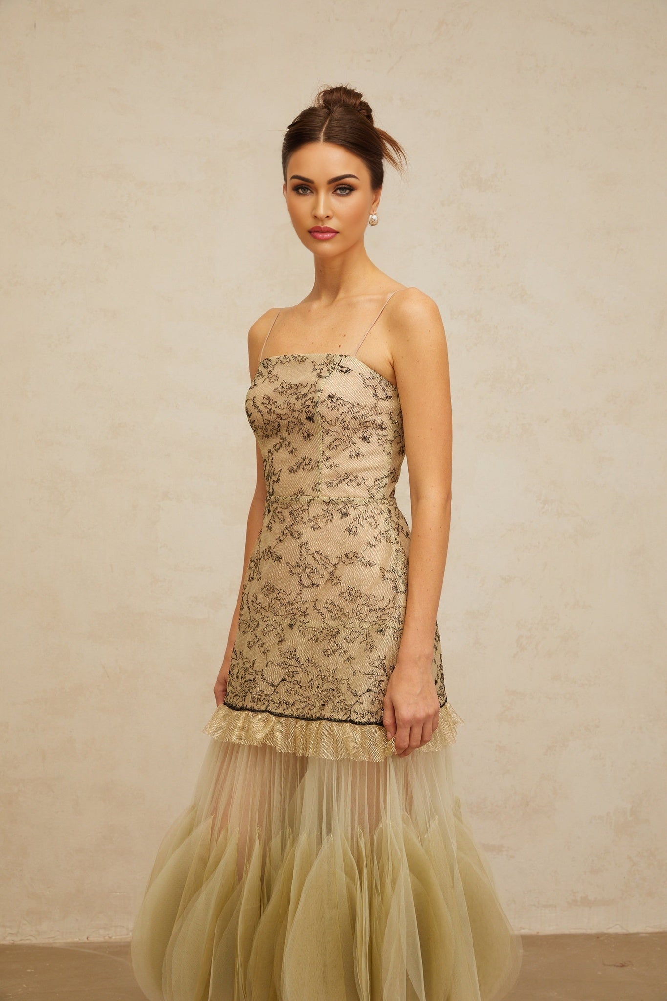 Woman wearing a green midi dress with embroidered panels and a flowy silhouette