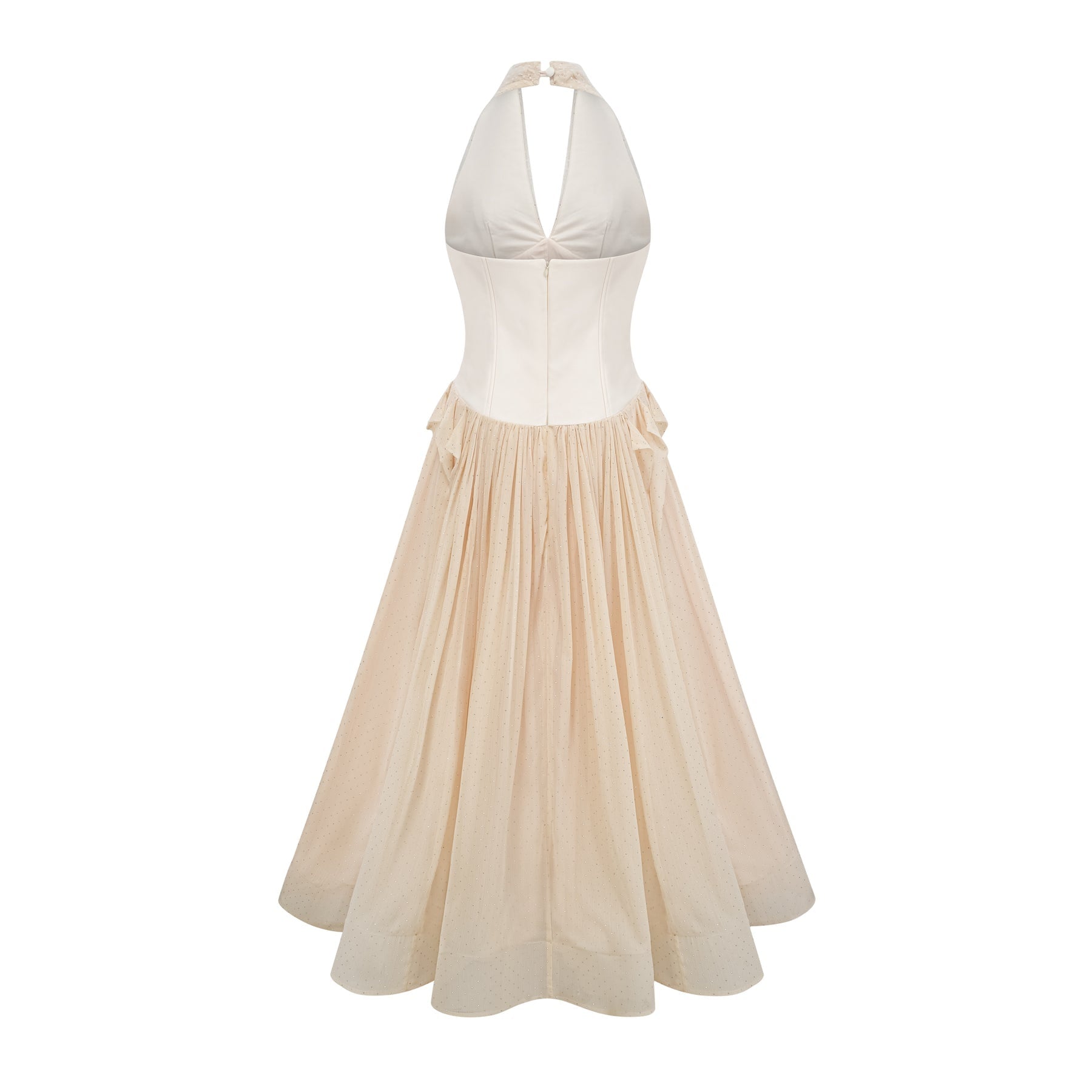 Woman wearing a halterneck tulle midi dress in light color standing against plain background