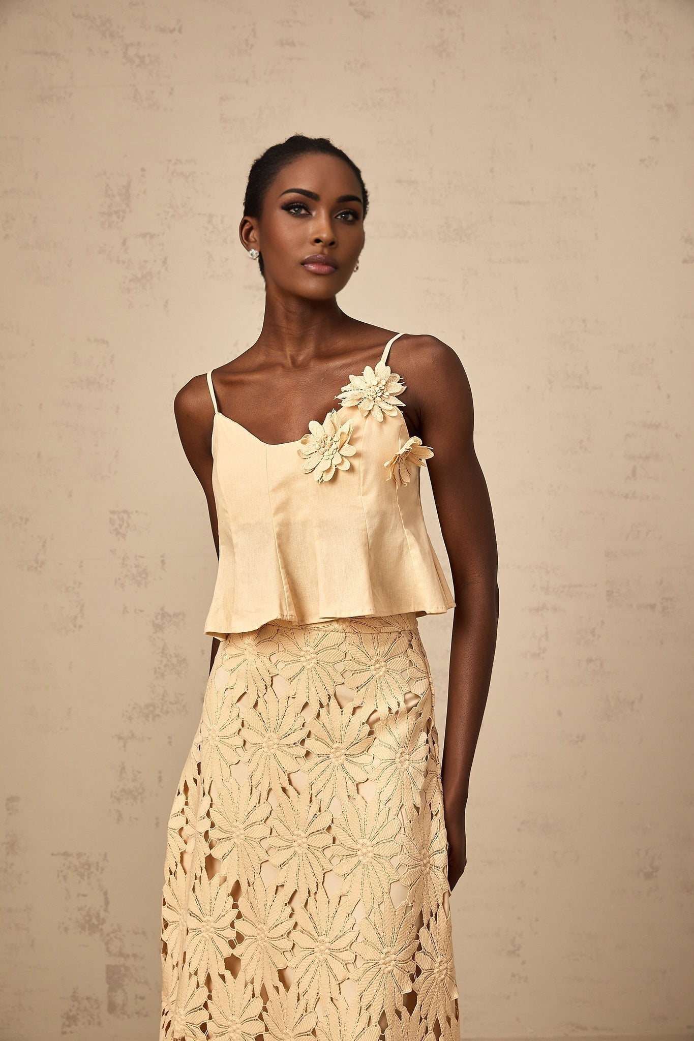 Woman wearing a khaki colored matching set consisting of a cutout flared top and skirt by Celine