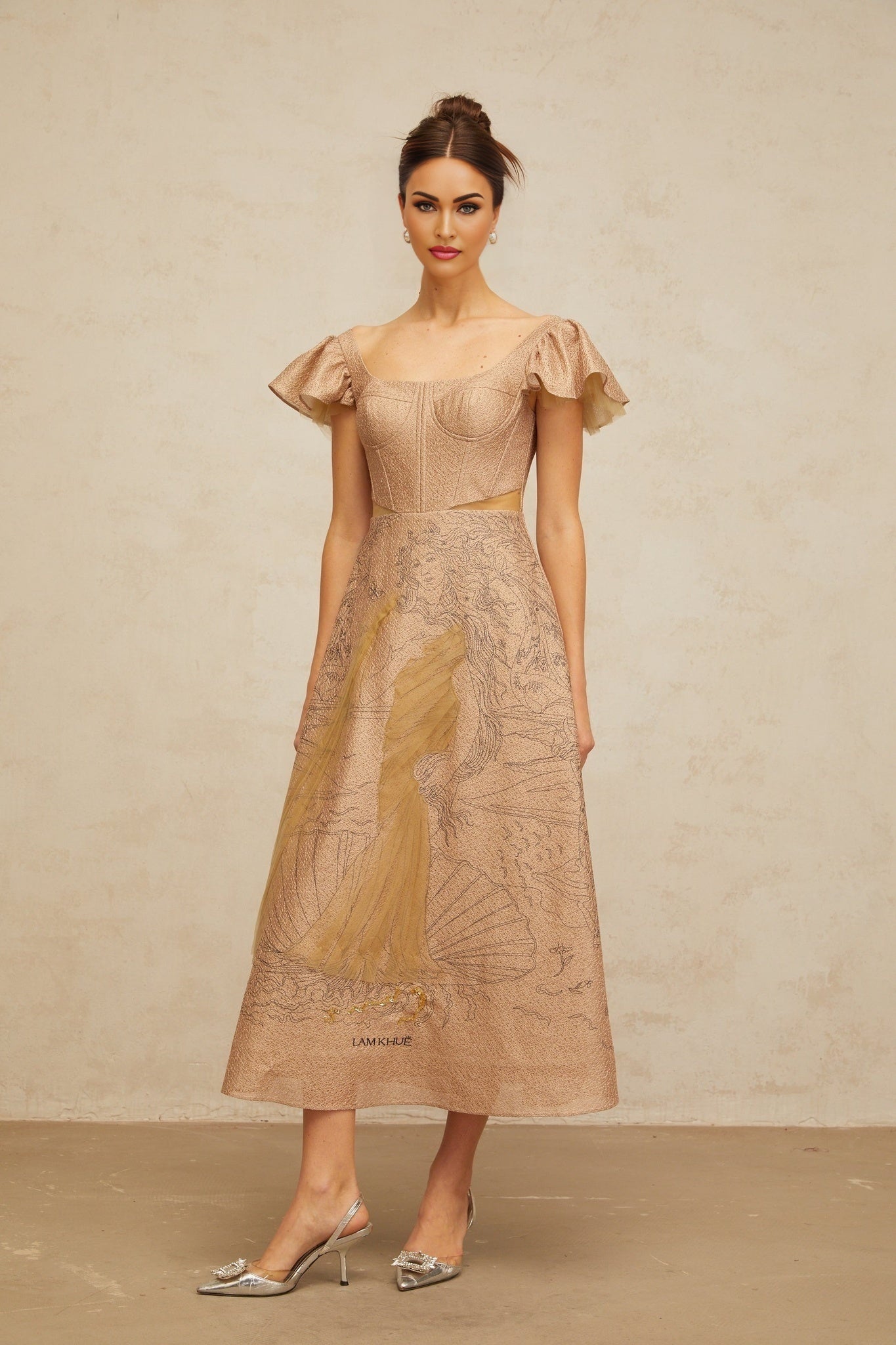 Woman wearing a khaki colored midi dress with flared skirt and graphic print pattern standing in neutral pose