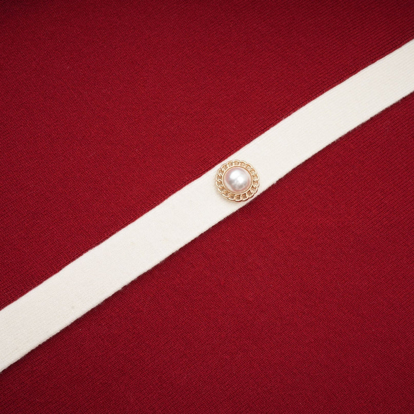 Woman wearing a knit offshoulder midi dress in soline color standing against a plain background