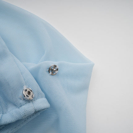 Woman wearing a light blue asymmetric pleated maxi dress with flowing fabric