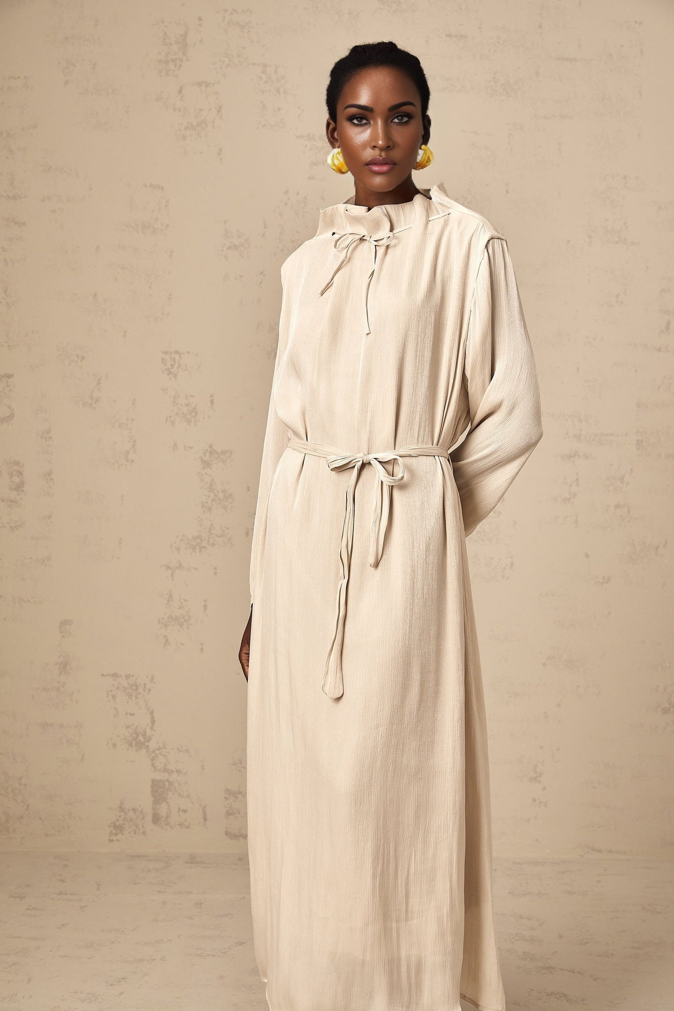 Woman wearing a light colored tulle midi dress with self tie waist and flowy skirt