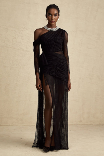 Woman wearing a long black dress with one shoulder strap and a cutout detail on the side