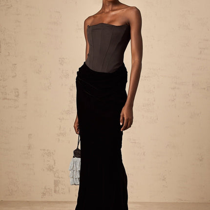 Woman wearing a long black velvet off shoulder maxi dress