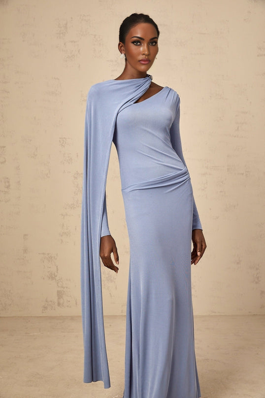 Woman wearing a long blue fitted maxi dress with a diagonal shawl neckline