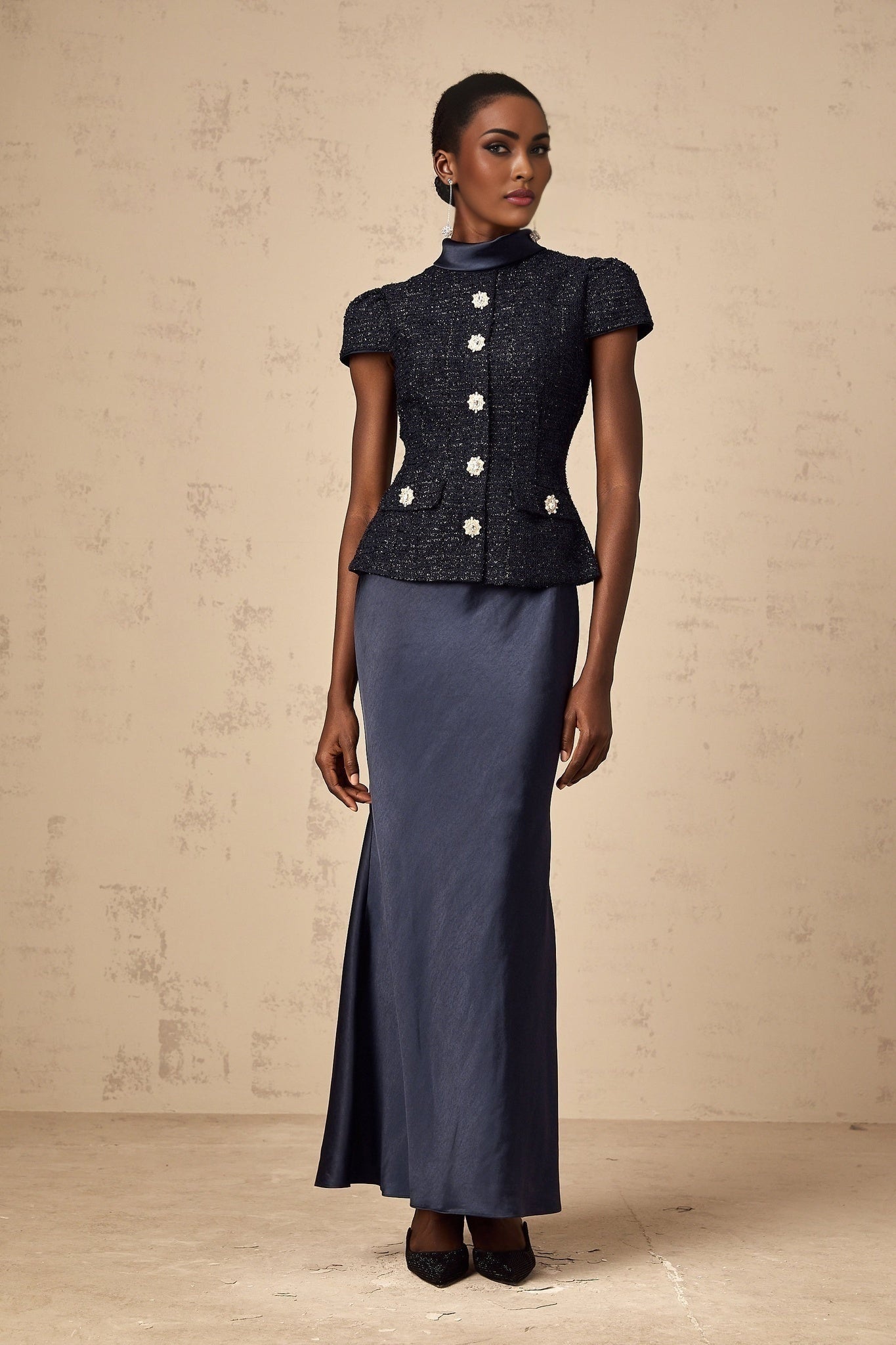 Woman wearing a long blue maxi dress with peplum waist and panelled design