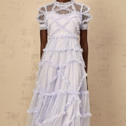 Woman wearing a long blue maxi dress with white polka dots and ruffled tulle details