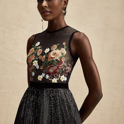 Woman wearing a long floral embroidered maxi dress with embellishments