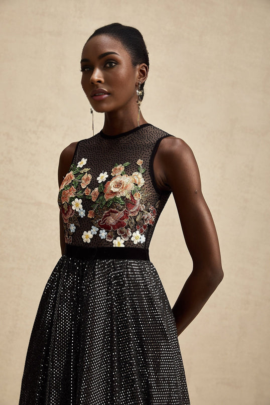 Woman wearing a long floral embroidered maxi dress with embellishments