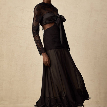 Woman wearing a long floral lace maxi dress with sheer panels elegant design in light color