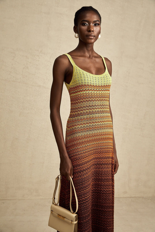 Woman wearing a long knitted maxi dress with gradient colors inspired by Audrey Hepburn style
