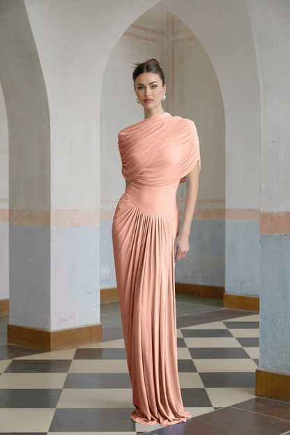 Woman wearing a long pink asymmetric pleated maxi dress with one shoulder strap
