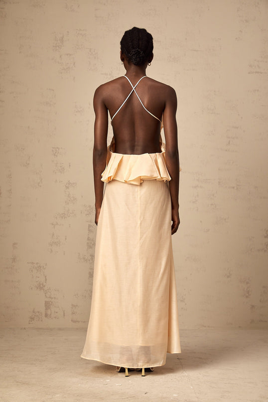 Woman wearing a long pink maxi dress with ruffled 3d petal details flowing from top to bottom