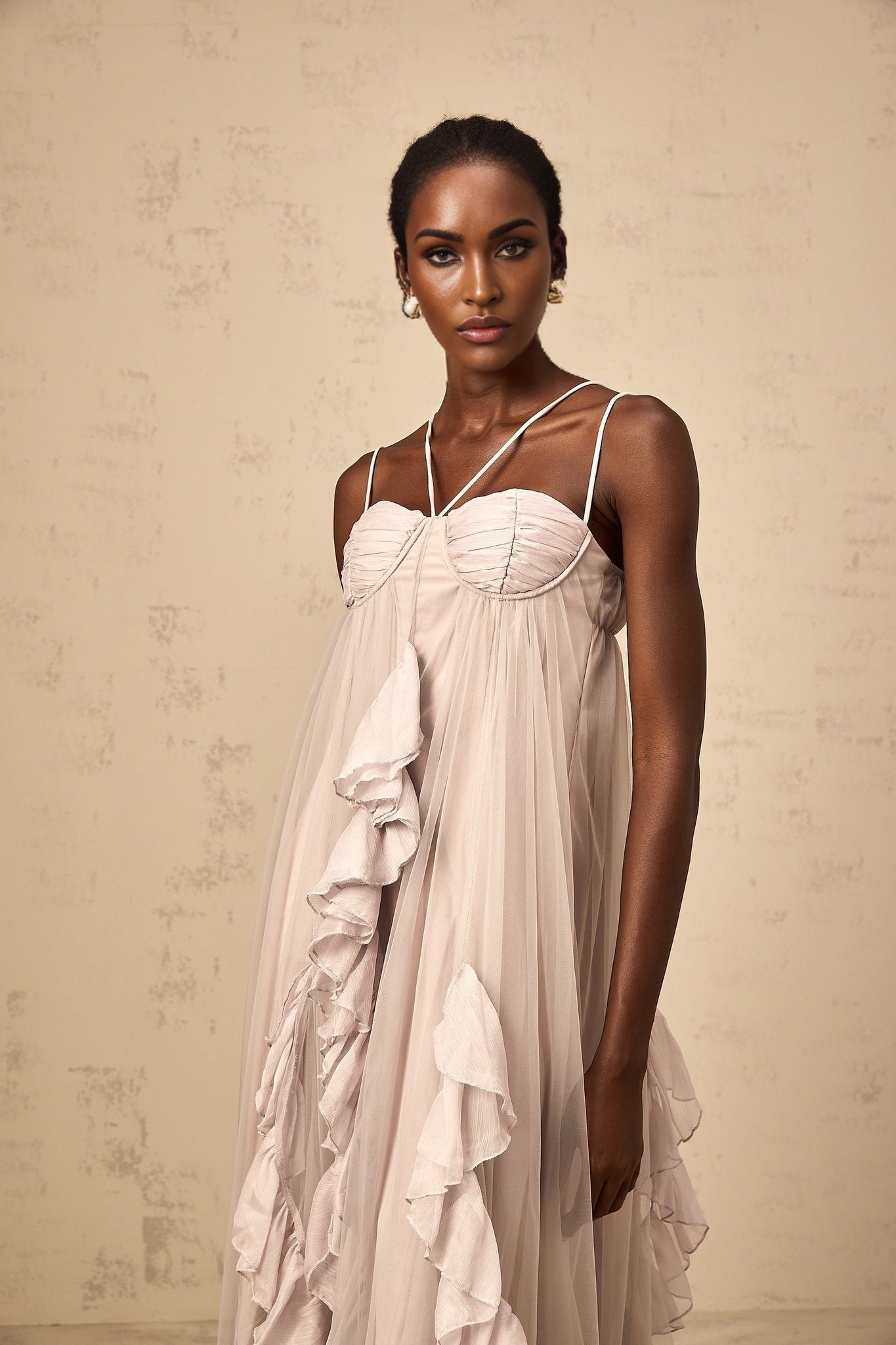 Woman wearing a long purple maxi dress with layered ruffled tulle skirt and fitted bodice