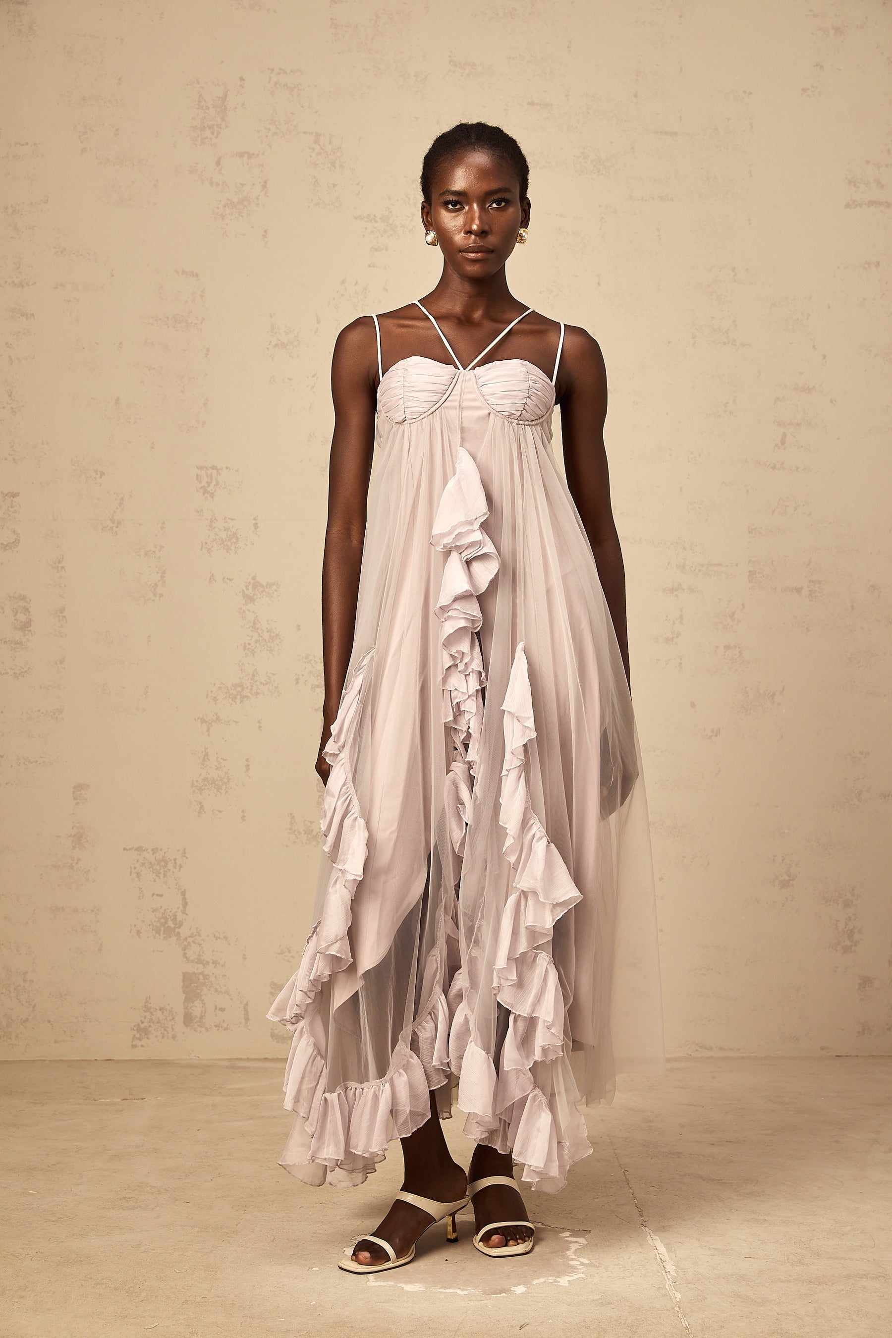 Woman wearing a long purple maxi dress with multiple layers of ruffled tulle skirt and fitted bodice
