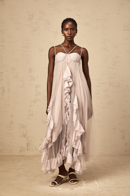 Woman wearing a long purple maxi dress with multiple layers of ruffled tulle skirt and fitted bodice