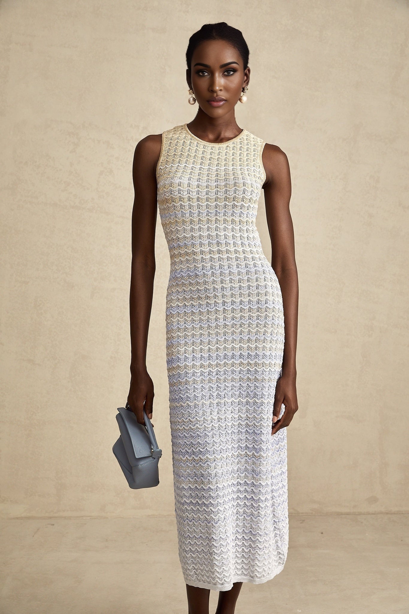 Woman wearing a long ribbed knit dress with contrasting color details and a midi length