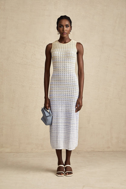Woman wearing a long ribbed knit dress with contrasting color details and midi length