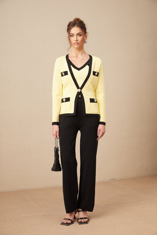 Woman wearing a matching knit set with cardigan vest and trousers featuring contrasting trim details