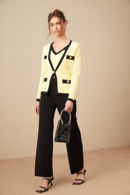 Woman wearing a matching knit set with cardigan vest and trousers in contrasting colors named Eloise