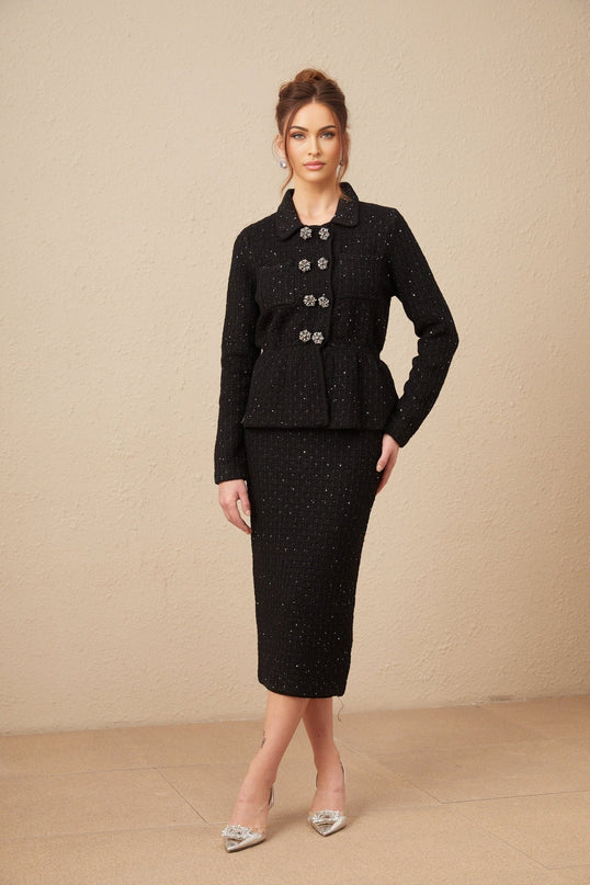 Woman wearing a matching sequined waffle knit jacket and skirt set in a shimmering fabric named Amina