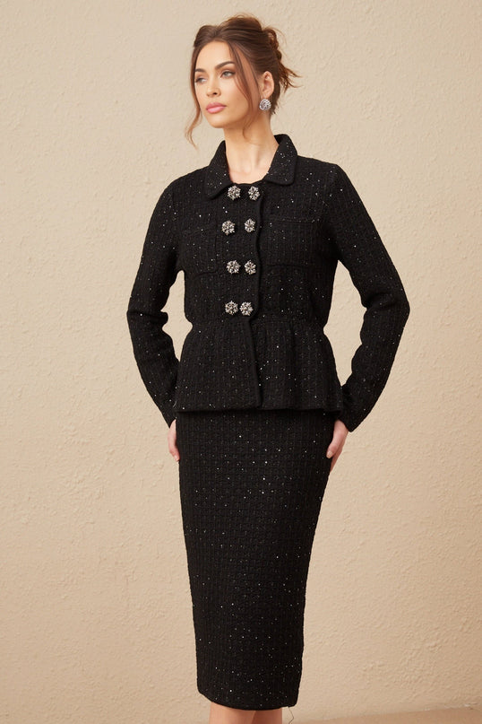 Woman wearing a matching sequined waffleknit jacket and skirt set in a shimmering fabric The outfit has a textured pattern and sparkles in the light