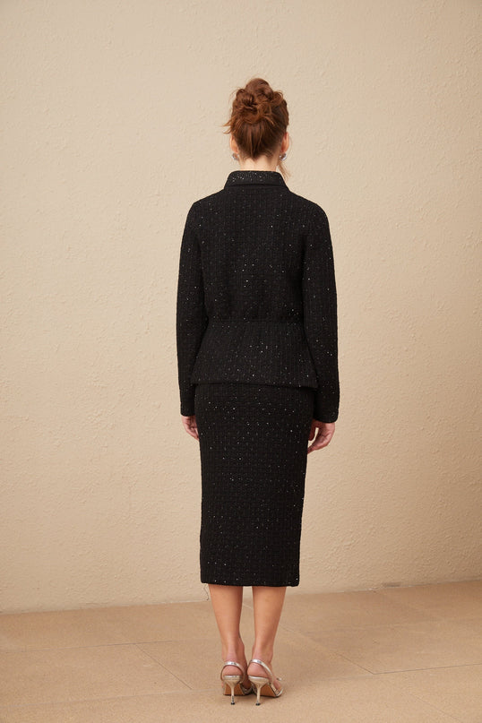 Woman wearing a matching sequined waffleknit jacket and skirt set in gold color with shimmering texture