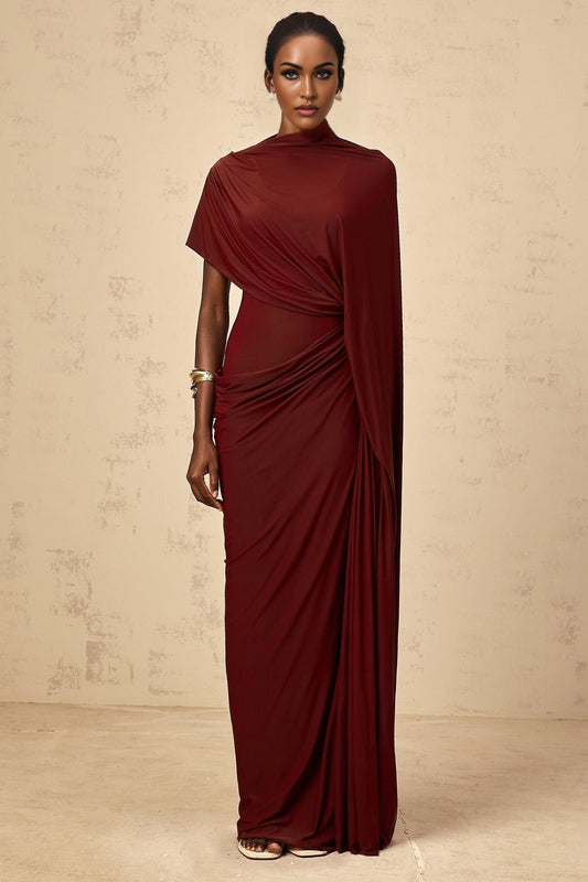 Woman wearing a matching set consisting of an asymmetrical draped cape and dress in a flowy fabric named Fenella