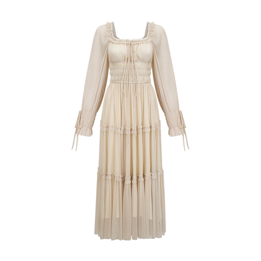 Woman wearing a metallic pleated midi dress with shirred details and a flowy silhouette named Camille