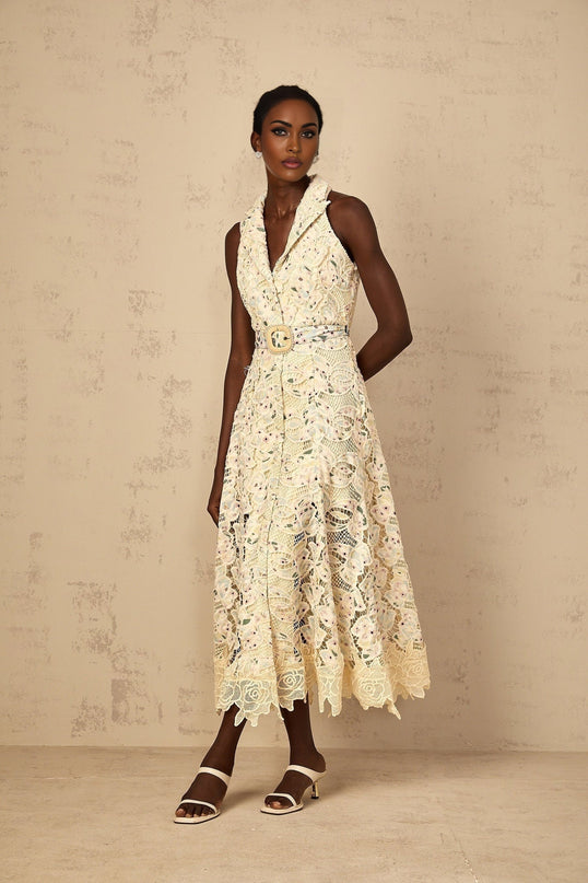 Woman wearing a midi length dress with floral embroidery and cutout details
