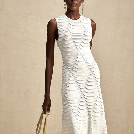 Woman wearing a midi length dress with snake pattern print and godet inserts for added flare