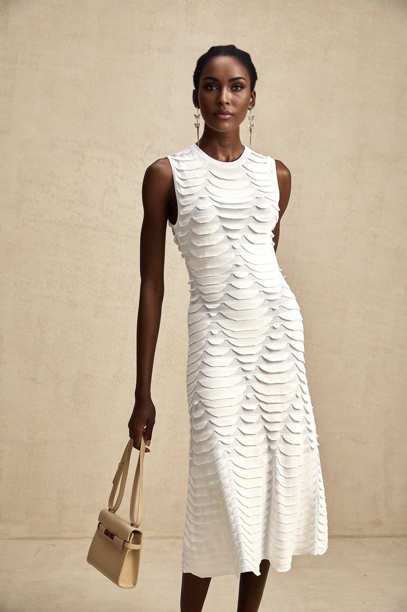 Woman wearing a midi length dress with snake pattern print and godet inserts for added flare