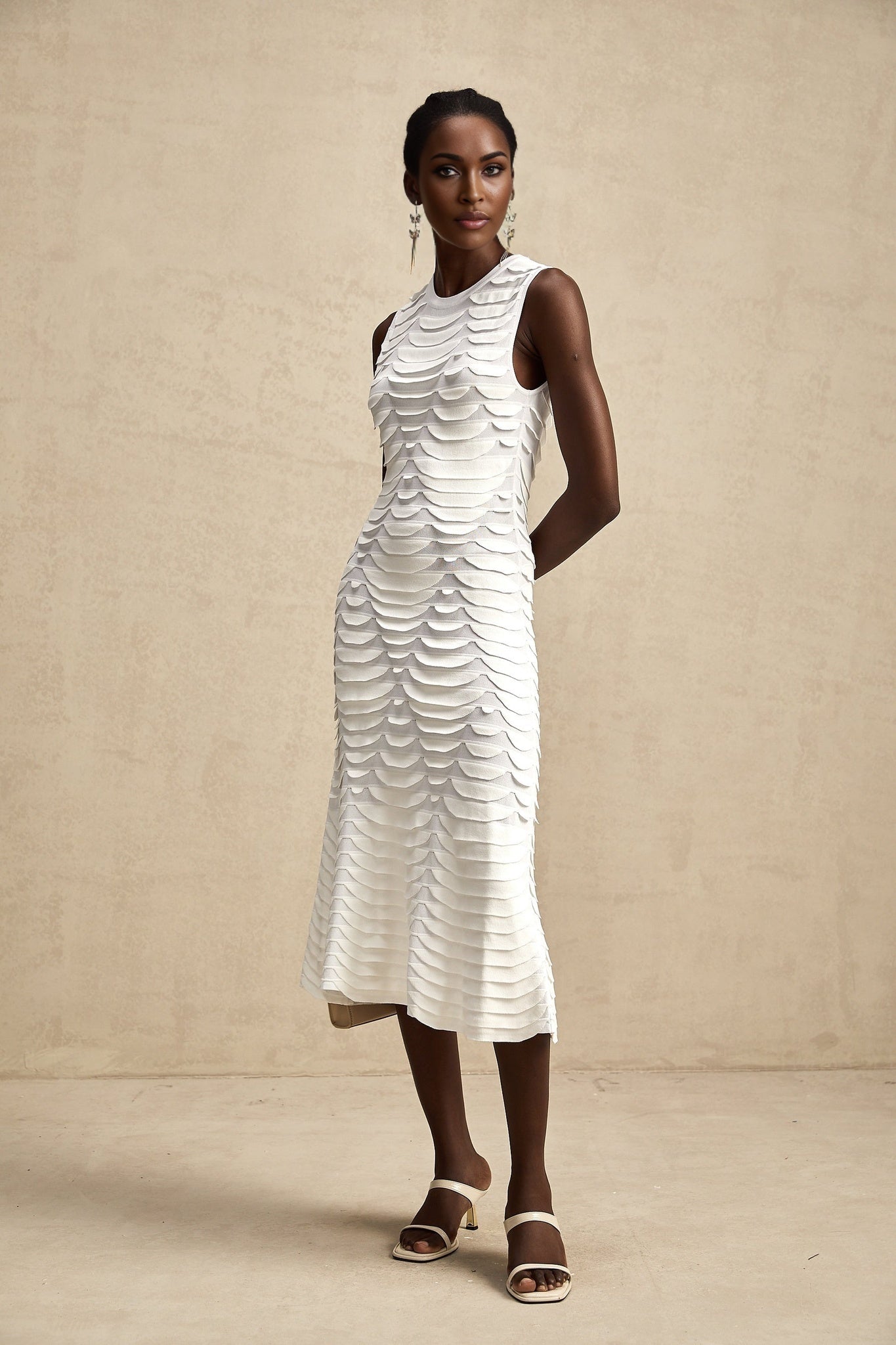 Woman wearing a midi length dress with snake pattern print and godet skirt design