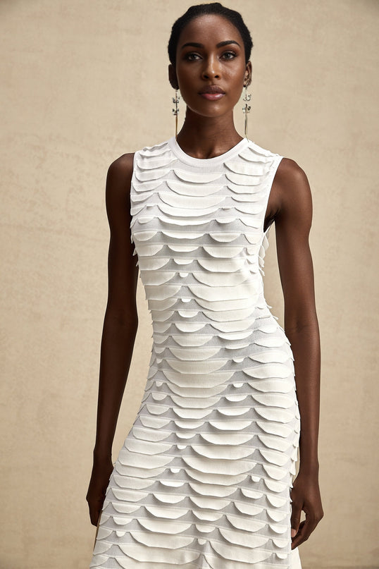 Woman wearing a midi length dress with snake pattern print and godet skirt design