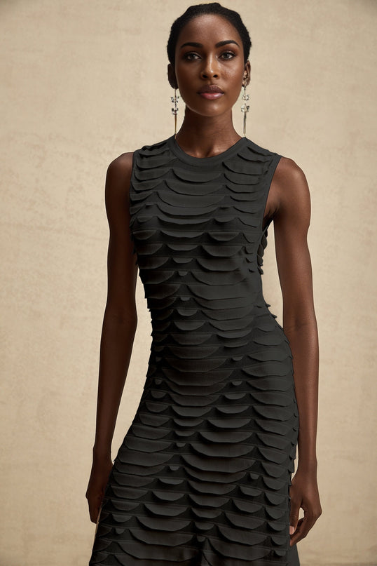 Woman wearing a midi length dress with snake pattern print and godet skirt details