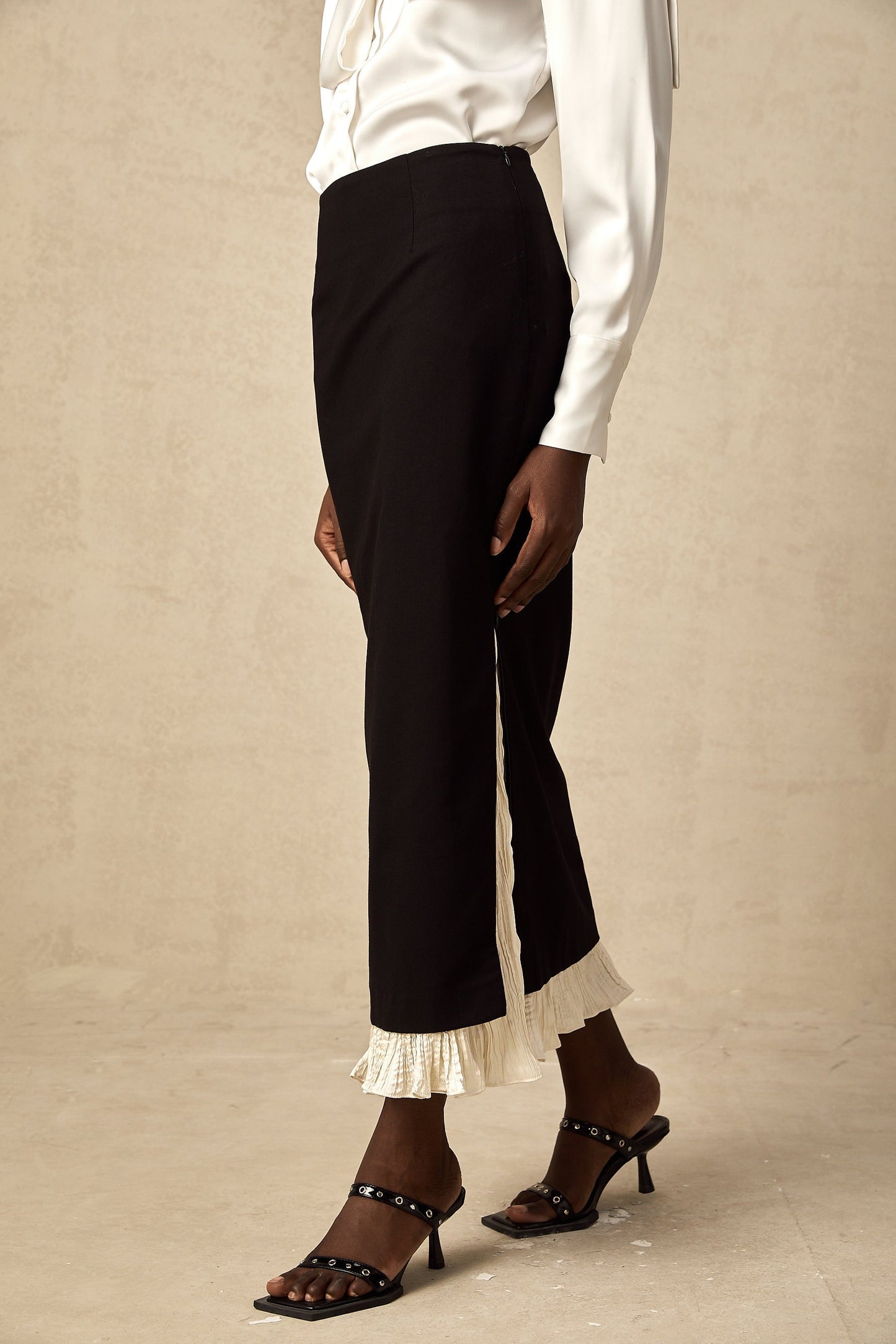 Woman wearing a midi length skirt with color block design and panels in contrasting colors