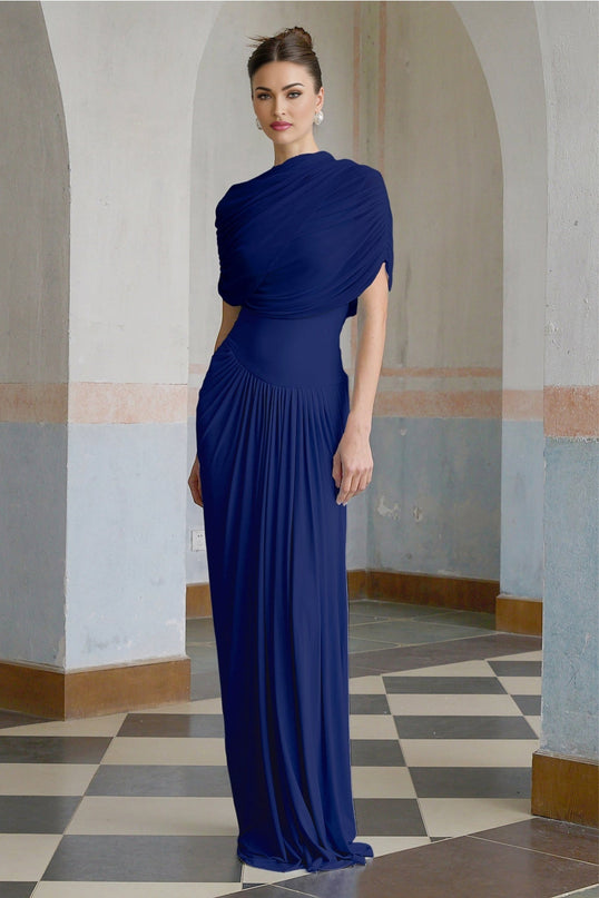 Woman wearing a navy blue asymmetric pleated maxi dress with long sleeves and a flowing skirt