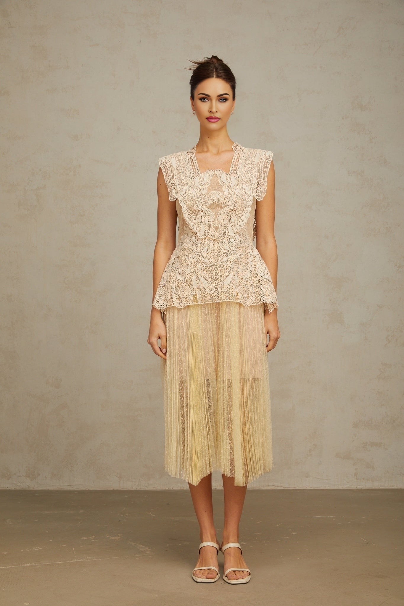 Woman wearing a neutral colored midi dress with floral lace panels and tulle skirt elegant formal attire