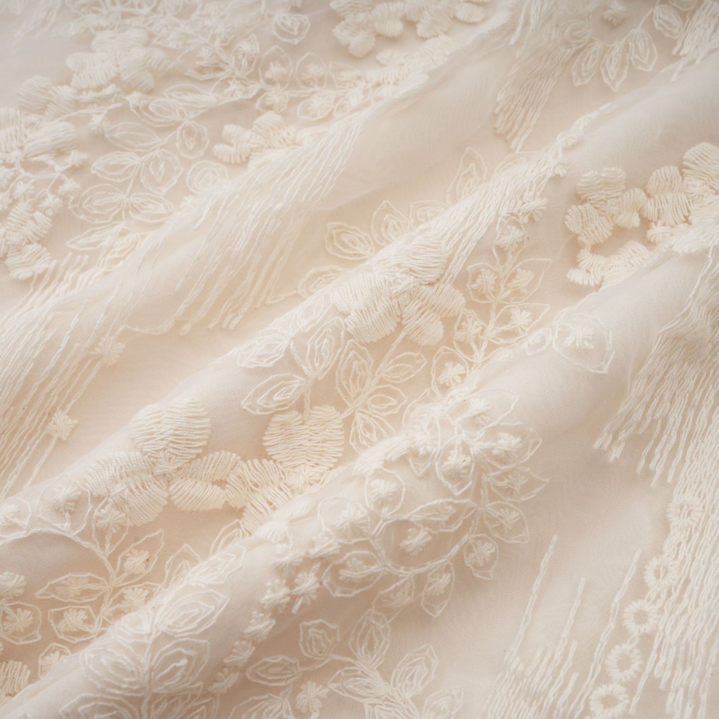 Woman wearing a neutral colored midi dress with lace embroidery details and short sleeves