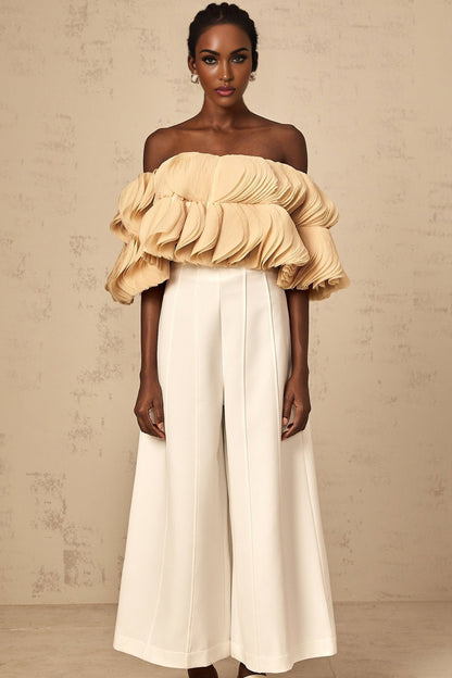 Woman wearing a neutral colored offshoulder cropped top with shirred design