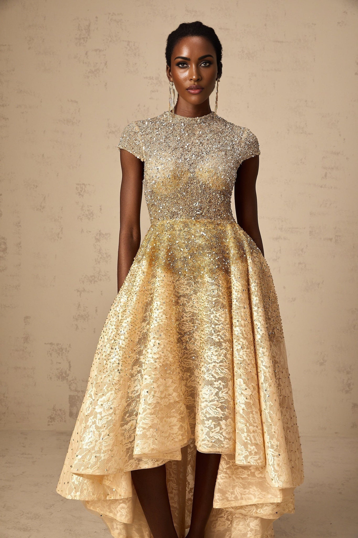 Woman wearing a neutral colored sequin dress with high low hemline
