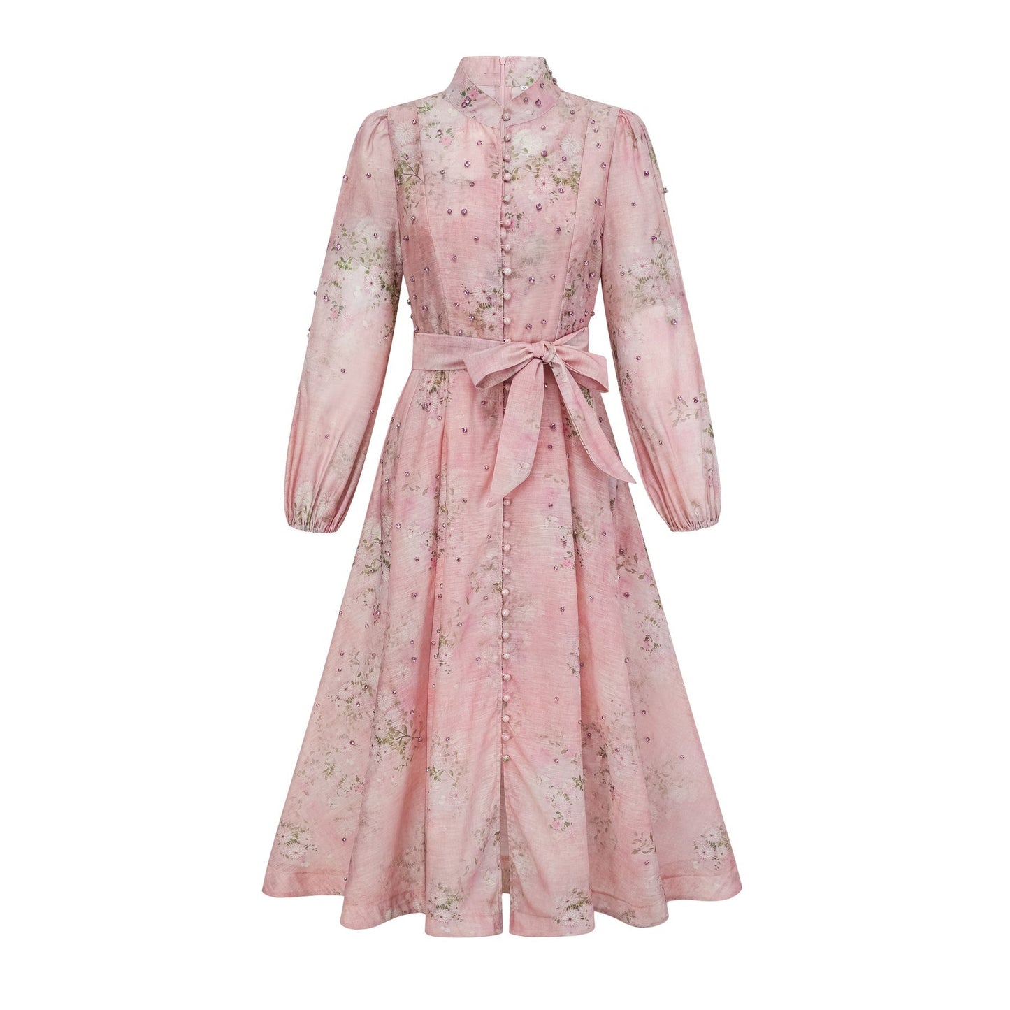 Woman wearing a pink midi dress with floral print and embellishments standing against a plain background