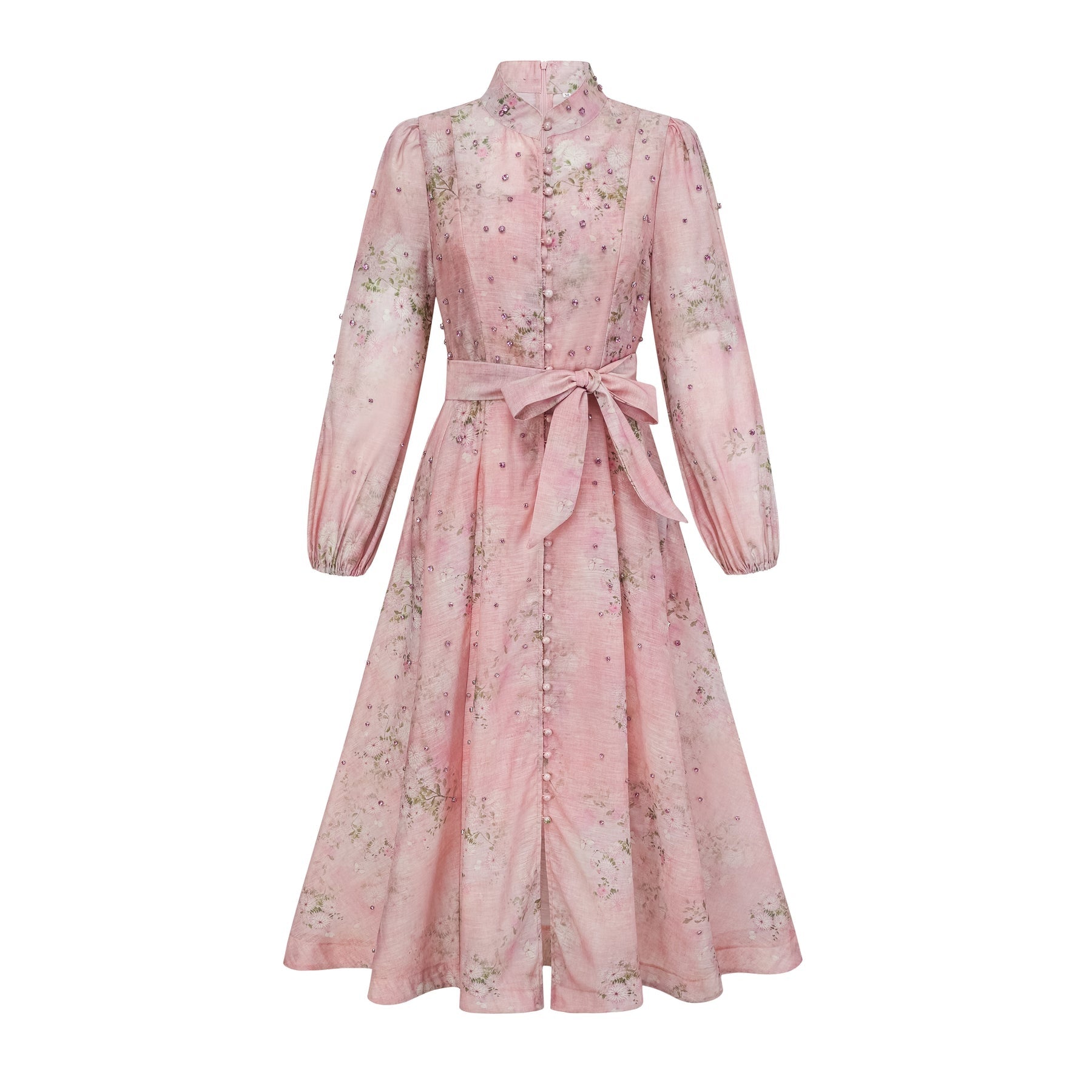 Woman wearing a pink midi dress with floral print and embellishments standing against a plain background