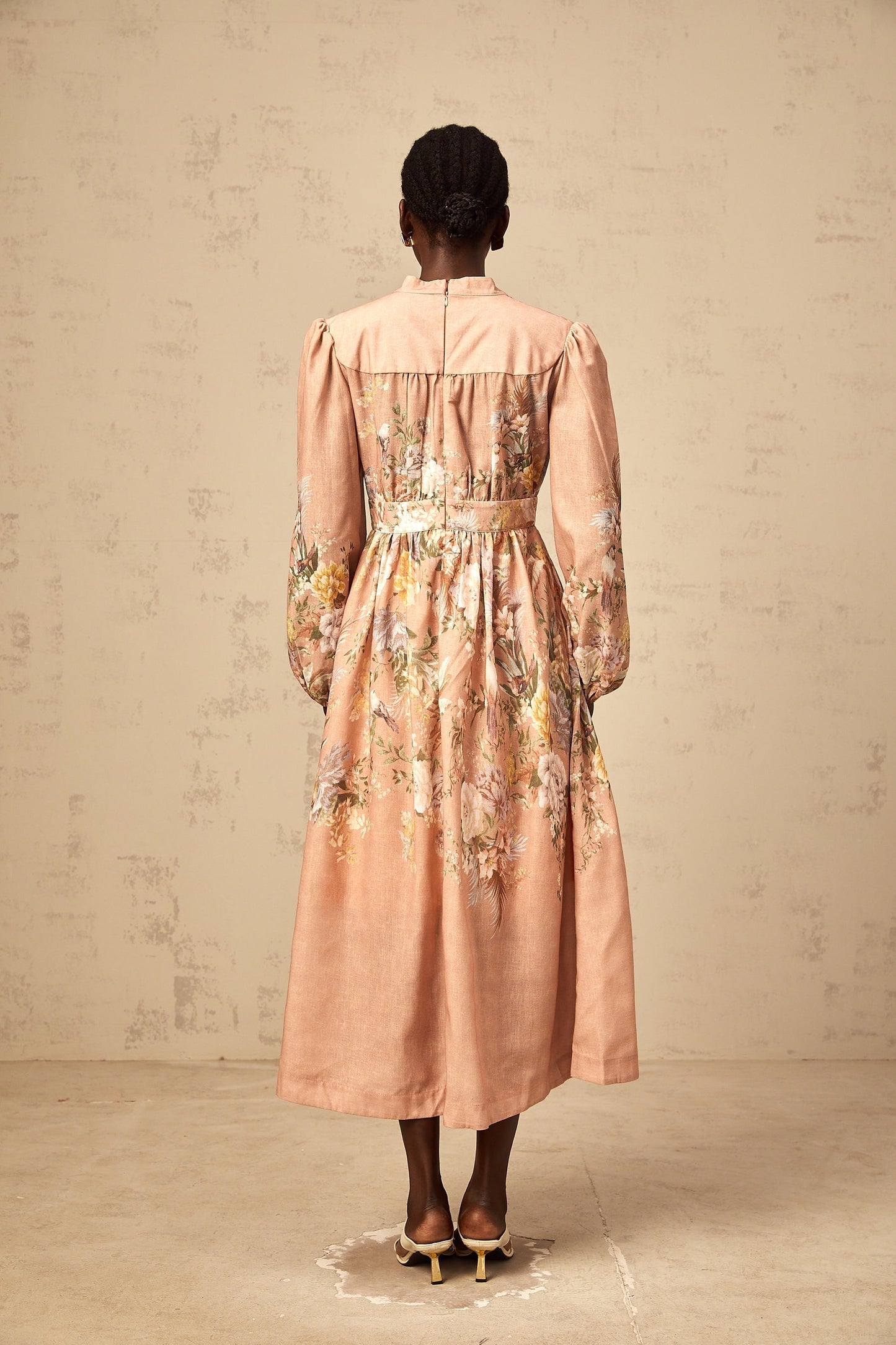 Woman wearing a pink midi dress with floral print and Vneck neckline